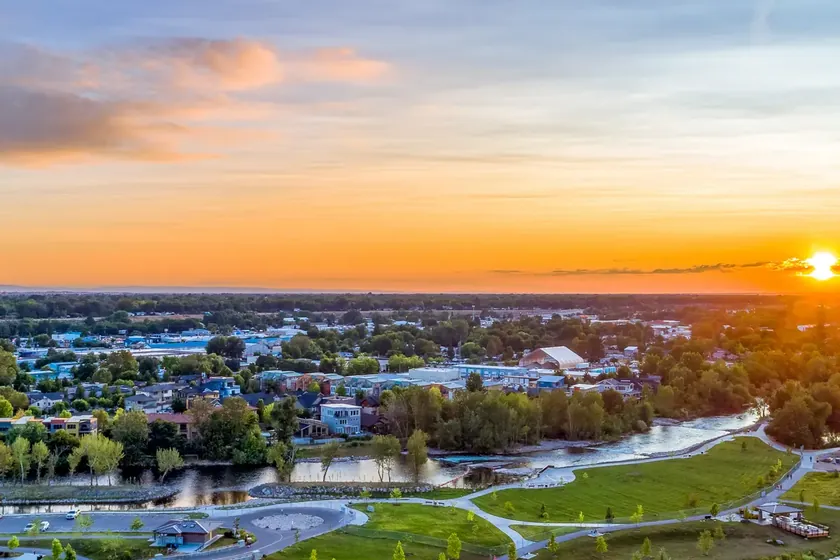 Aerial view of the Boise River greenbelt and Treasure Valley neighborhoods at sunset.