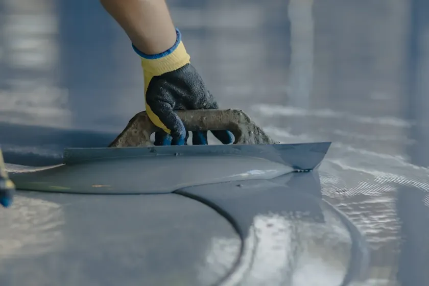 A floor coating being smoothed onto prepared concrete.