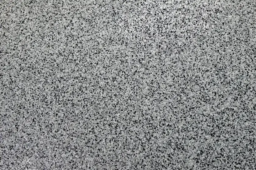 Close-up of a gray, black and white flake garage floor finish.